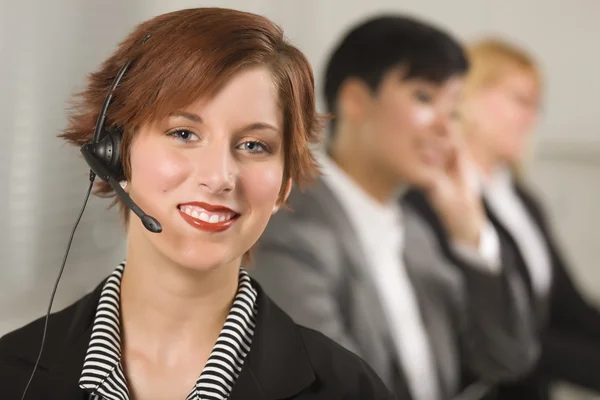 Pretty Red Haired Businesswoman with Headset and Colleagues — Stock Photo, Image