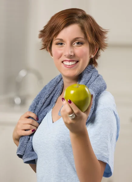 Vrij rood donkerharige vrouw met handdoek bedrijf groene appel — Stockfoto
