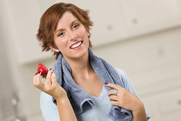 Docela rusovláskou drží jahoda — Stock fotografie