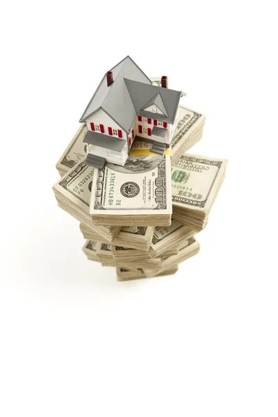Litet hus på högar av hundra dollar räkningar — Stockfoto