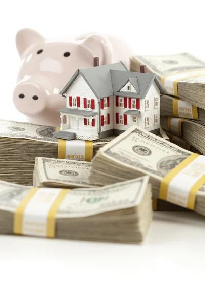 Casa pequena e banco porquinho com dinheiro de pilhas — Fotografia de Stock
