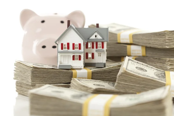 Casa pequena e banco porquinho com dinheiro de pilhas — Fotografia de Stock