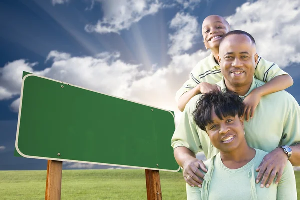 Familia afroamericana frente al letrero verde en blanco —  Fotos de Stock