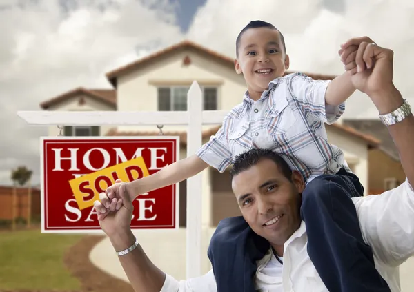 Padre e hijo hispanos en frente de la casa, letrero vendido —  Fotos de Stock