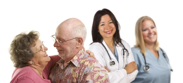 Старшая пара с врачами или медсестрами за спиной — стоковое фото