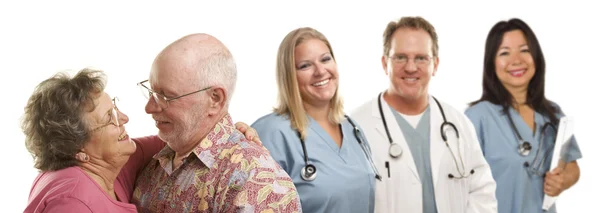 Senior koppel met artsen of verpleegkundigen achter — Stockfoto