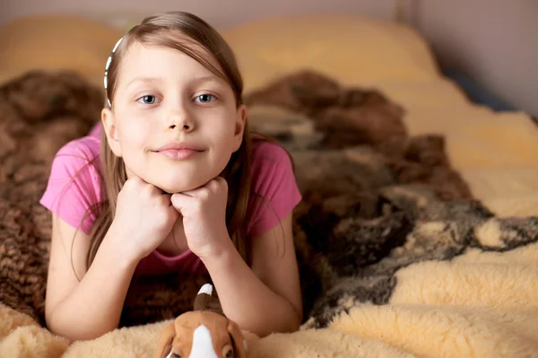 Porträtt av en liten flicka i sängen — Stockfoto