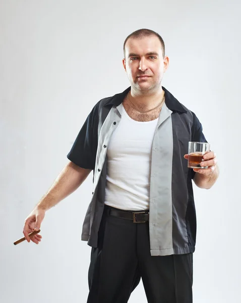 Porträt eines ernsthaften harten Kerls mit Zigarre und einem Glas Alkohol — Stockfoto