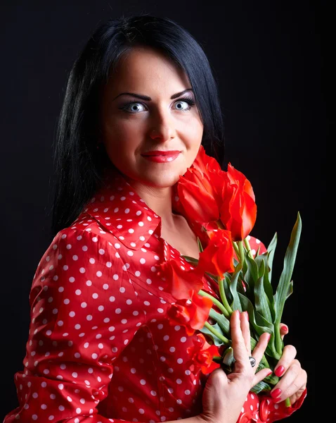 Jonge vrouw met rode bloemen — Stockfoto