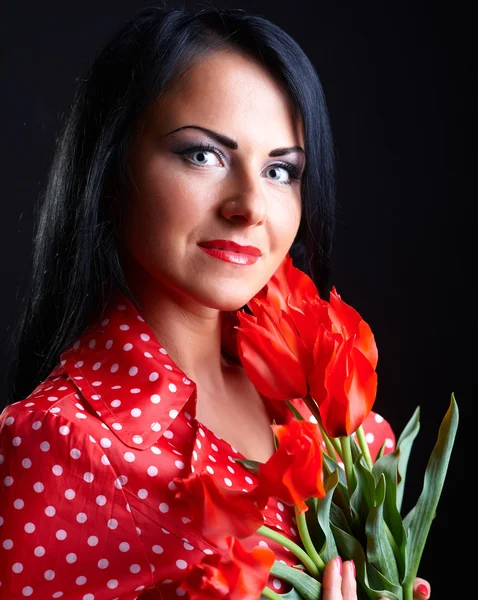 Junge Frau mit roten Blumen — Stockfoto
