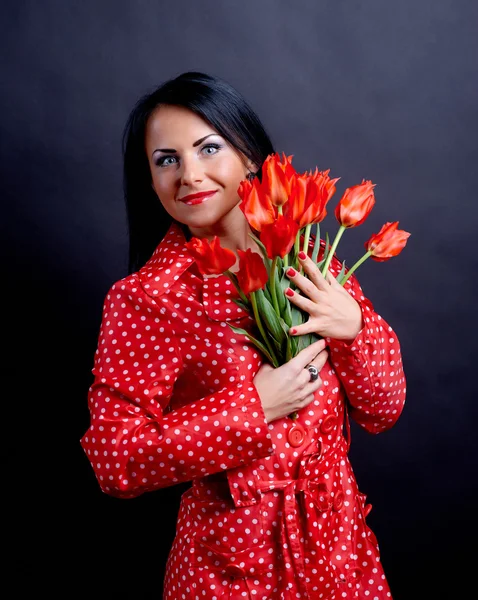 Mujer joven con flores rojas —  Fotos de Stock
