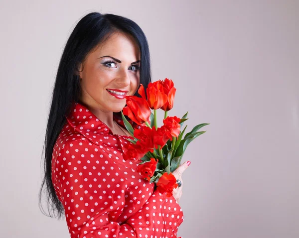 Portrait of a woman with red flowers — Stock Photo, Image