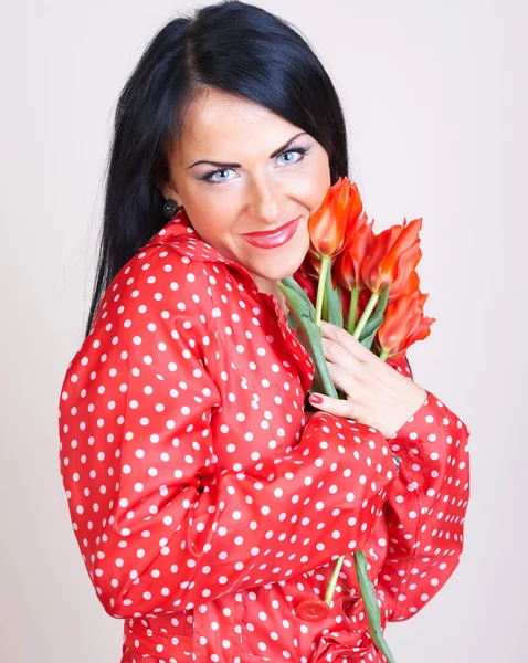 Portret van een vrouw met rode bloemen — Stockfoto