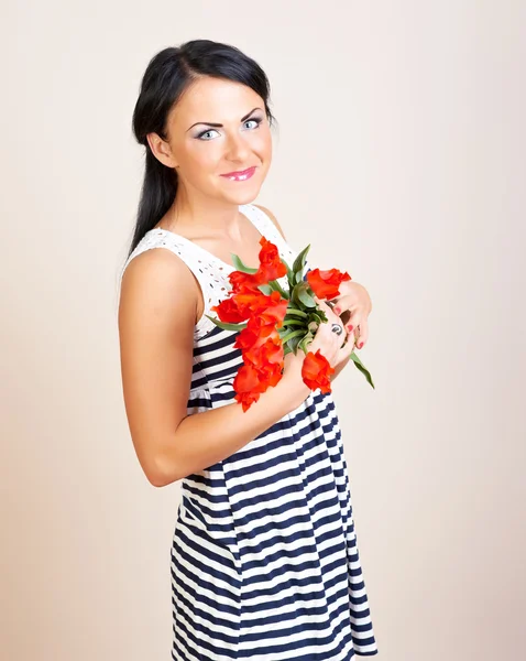 Portrait of a woman with red flowers, studio shot — Stock Photo, Image
