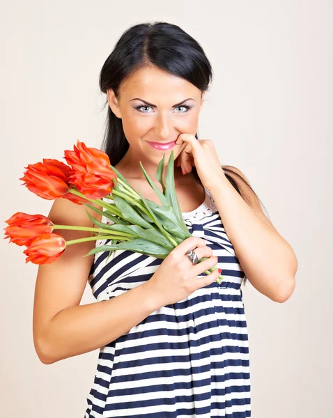 Portrait of a woman with red flowers, studio shot — Stock Photo, Image