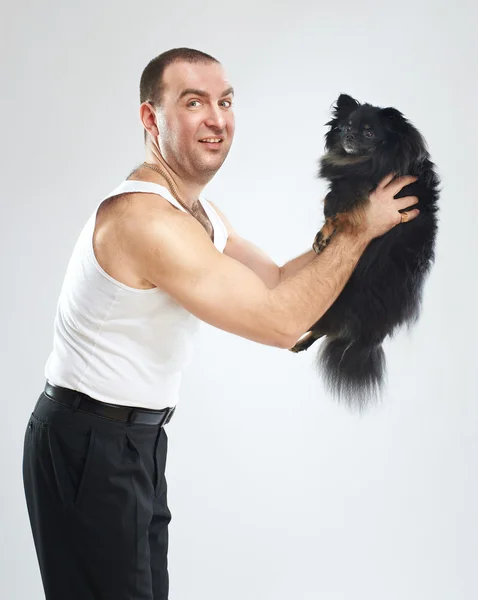 Αστείος άνθρωπος με μικρό μαύρο σκυλί — Φωτογραφία Αρχείου
