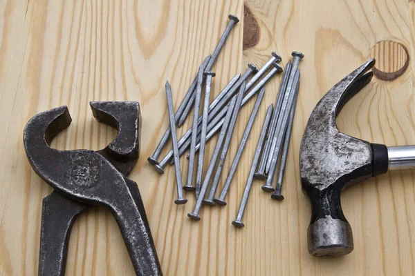 Hamer, moersleutel en nagels op hout achtergrond — Stockfoto
