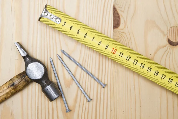 Vieux marteau, ruban à mesurer et ongles — Photo