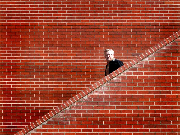 계단 벽돌 벽 아래로 산책 하는 남자 — 스톡 사진