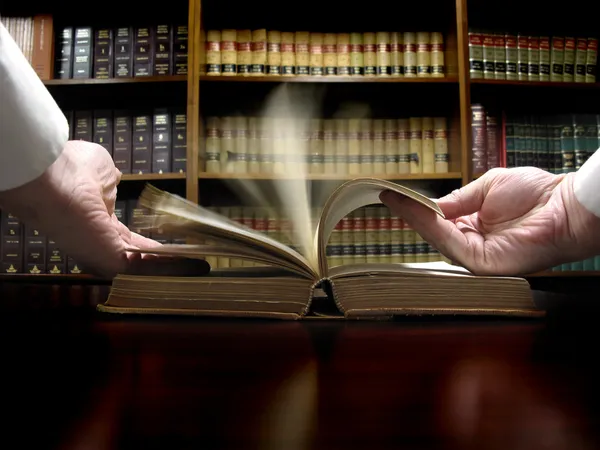 Рука на юридичній книзі — стокове фото