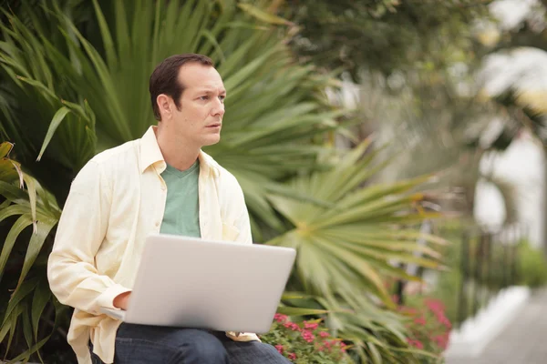 Man looking away from his notebook computer — Stock Photo, Image