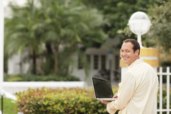 Man with a notebook computer smiling — Stock Photo, Image