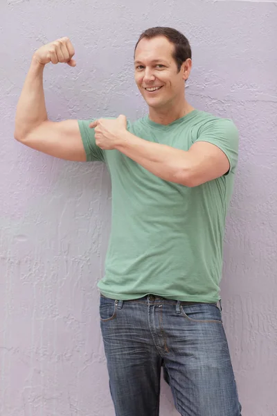 Homem flexionando seus músculos — Fotografia de Stock