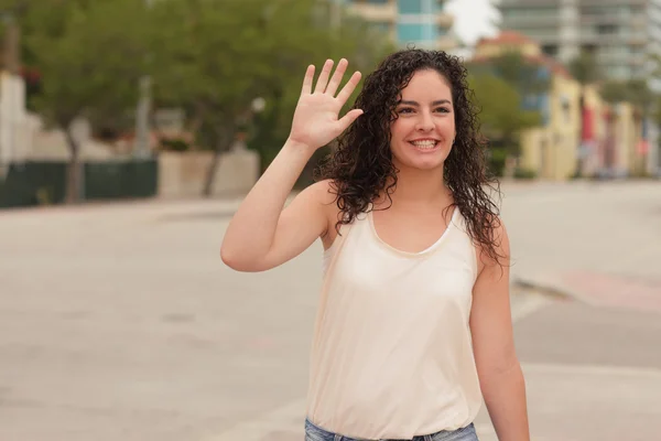 Woman waving and smiling — Stock Photo, Image