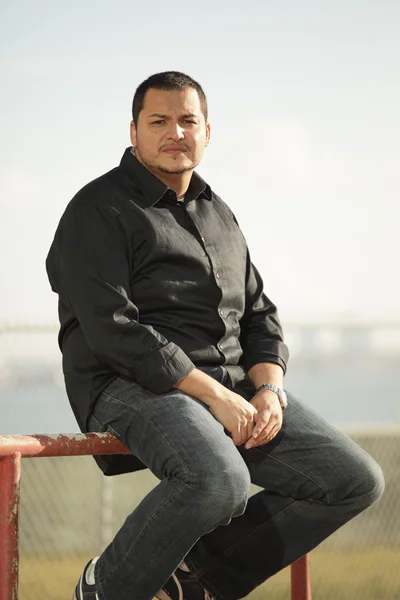 Latino homem sentado ao ar livre — Fotografia de Stock