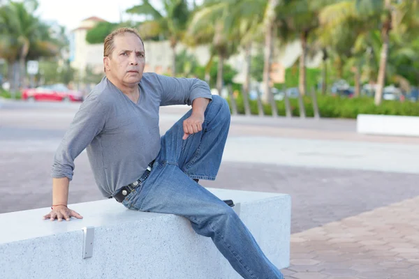 Mature adult sitting on a park bench — Stock Photo, Image