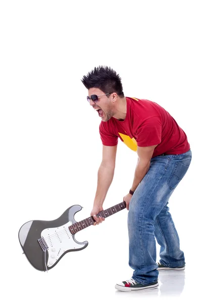Zły człowiek trzyma gitarę i próbuje złamać — Zdjęcie stockowe