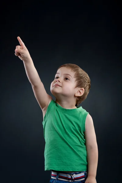 Gelukkige jongen die met zijn vinger omhoog wijst — Stockfoto