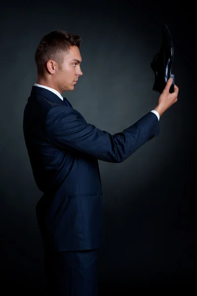 Мужчина в элегантном костюме и ботинках в руке — стоковое фото