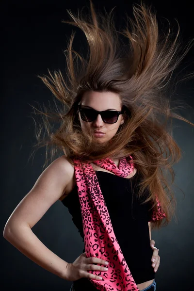 Frau mit geblasenen Haaren trägt Sonnenbrille — Stockfoto