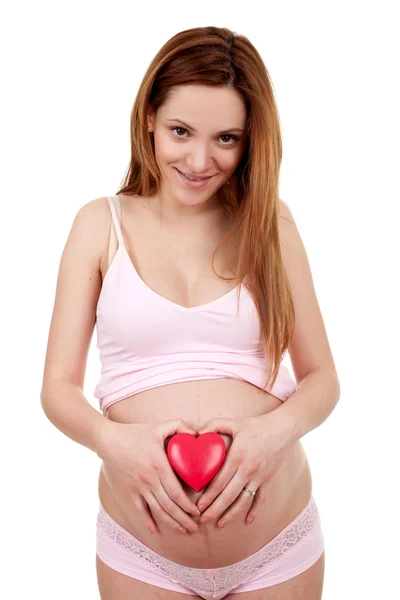 怀孕的女人举行红色心 — 图库照片