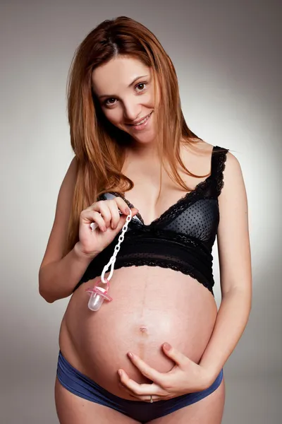 Mulher grávida com chupeta de bebê — Fotografia de Stock