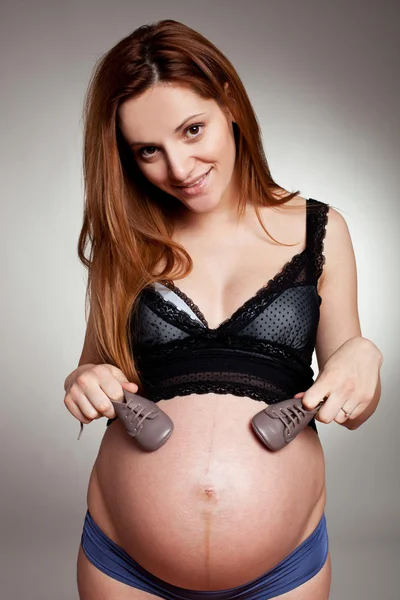 Mujer embarazada con zapatos pequeños —  Fotos de Stock