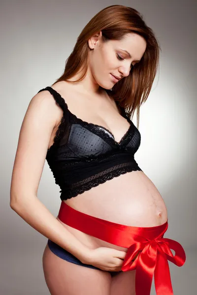 Jeune femme enceinte avec un ruban — Photo