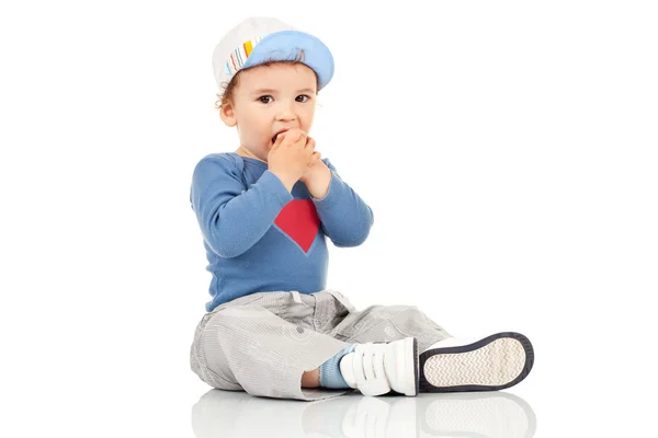 Kid sitting and holding his hands near the mouth — Stock Photo, Image