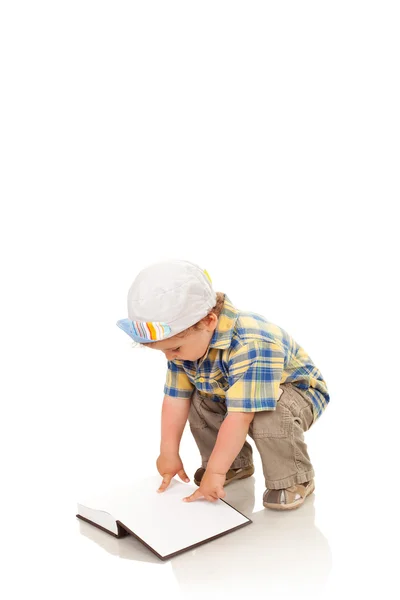 Маленький мальчик играет в белую книгу — стоковое фото