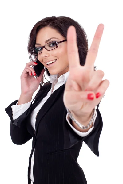 Деловая женщина с телефоном и победным жестом — стоковое фото