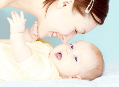 Young mother is playing with her little baby girl clipart