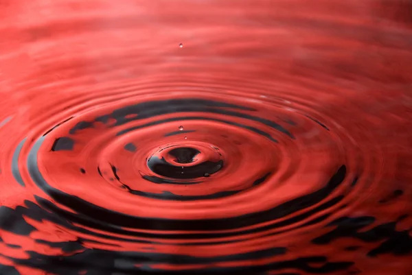 Water droplet tegen rood — Stockfoto