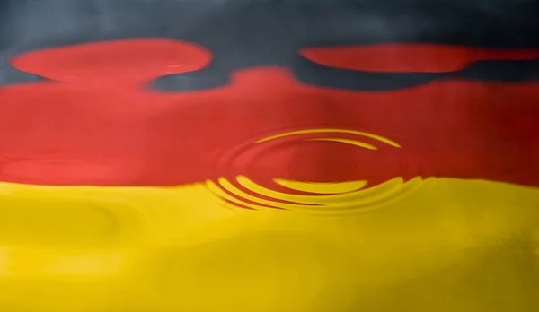 Water droplet tegen een Duitse vlag — Stockfoto