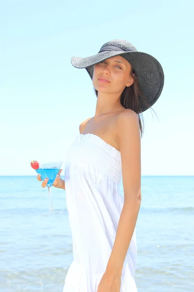 Mladá žena na pláži s koktejlem — Stock fotografie
