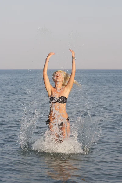 Piękna kobieta wskakuje z morza — Zdjęcie stockowe