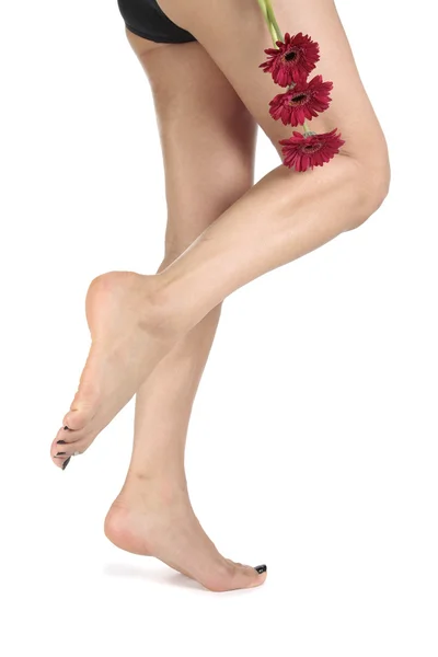 Γυναίκα τα πόδια με λουλούδια που απομονώνονται σε λευκό φόντο — Φωτογραφία Αρχείου