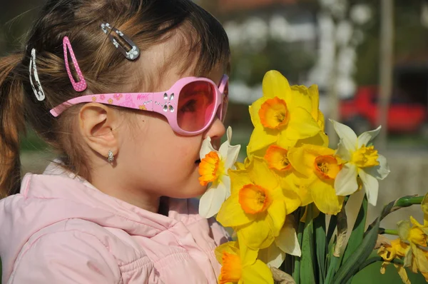 Roztomilá holčička s květinami v ruce — Stock fotografie