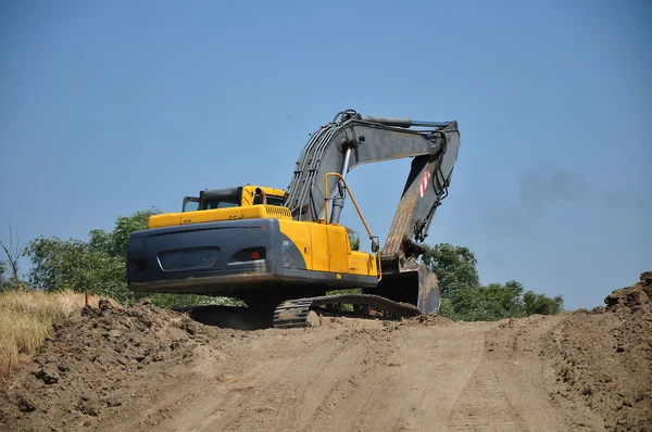 Gul grävmaskin på byggarbetsplats — Stockfoto