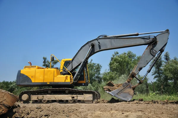 Excavadora amarilla en el sitio de construcción —  Fotos de Stock